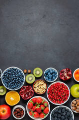 Food with a high content of antioxidants: berries, nuts, fruits. Black concrete background. Copy space