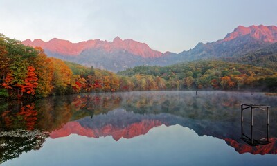 Amazing autumn lake scenery of Kagami Ike (Mirror Pond) in morning light with symmetric reflections...