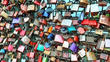 Love locks hanging on a metal bridge