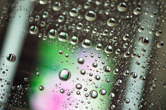 Wassertropfen auf Glas &ndash; abstrakte Nahaufnahme mit bunten Reflexionen