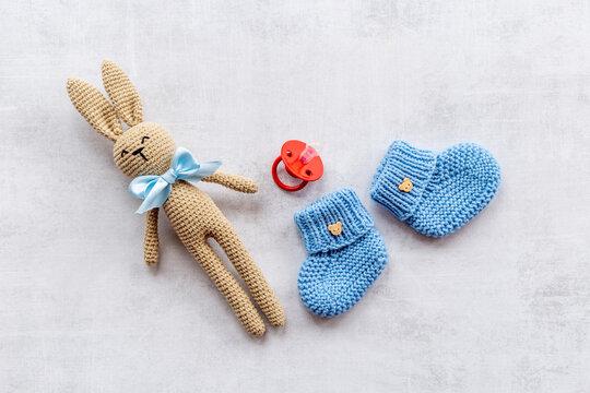 Kids toy knitted rabbit with baby booties shoes, top view