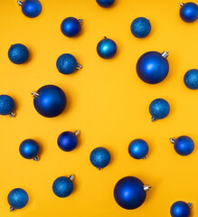 Blue Christmas decoration on yellow background. Flat lay concept.