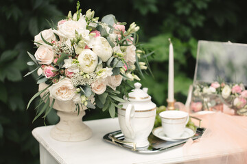 Still life morning of the bride, a dish with a cup of tea, a jewelry box, wedding rings and a bouquet of flowers