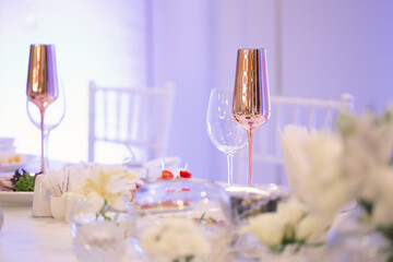 Table at a luxury wedding reception. Beautiful flowers on the table. Serving dishes, glass glasses