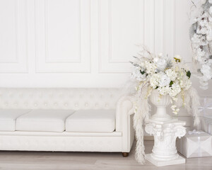 Fototapeta na wymiar white sofa and white vase with flowers
