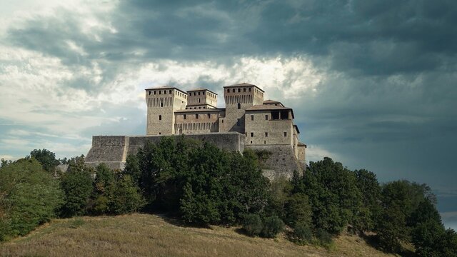 Historic medieval fortress of Torrechiara Castle stands majestically on a hill in Parma, Italy under dramatic skies.. Parma, Italy. 04.05.2025 