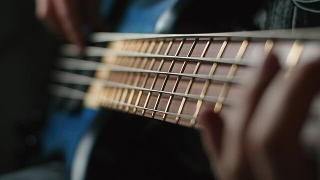 Bassplayer plays with his fingers on the modern 5 string bass in slow motion, 1080p 240fps