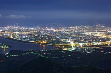 Aerial panorama over Taipei, the capital City of Taiwan, on a blue gloomy evening with view of the...