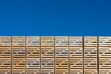 stack of empty pallets in front of blue sky