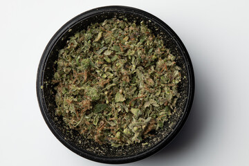 Grinder with Crushed buds of marijuana weed cannabis isolated, medical marijuana