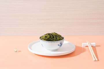 Seaweed, an Asian food ingredient, full of vitamins and minerals. Minimalistic zen conceptual still life with trendy color 2022 calming coral. Long harsh shadows, copy space