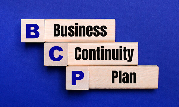 On a bright blue background, light wooden blocks and cubes with the text BCP Business Continuity Plan