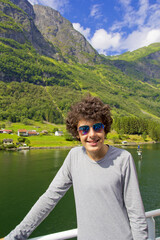 happy boy smiling at camera in norway fjords