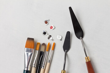 Foil caps from tubes of paint and a set of art brushes and palette knives