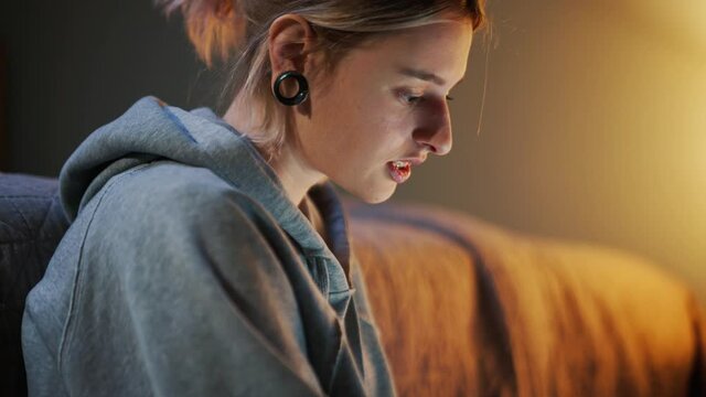 Side view of smiling woman looking at laptop at home
