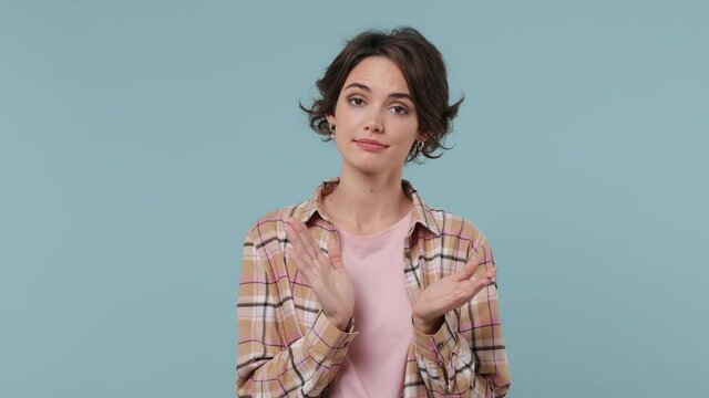 Sarcastic ironic skeptical young brunette woman 20s wears plaid shirt applause cheering clapping hands isolated on pastel plain light blue background studio portrait. People emotions lifestyle concept
