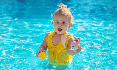 Fototapeta na wymiar Baby swims in the pool. Selective focus.