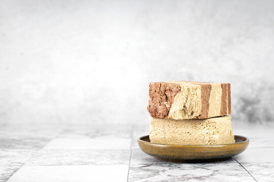 Tasty eastern sweet dessert halva from sunflower seeds, cocoa and tahini on gray background.Traditional dessert confection in Middle East, Balkans and west Asia.Horizontal.Copy space