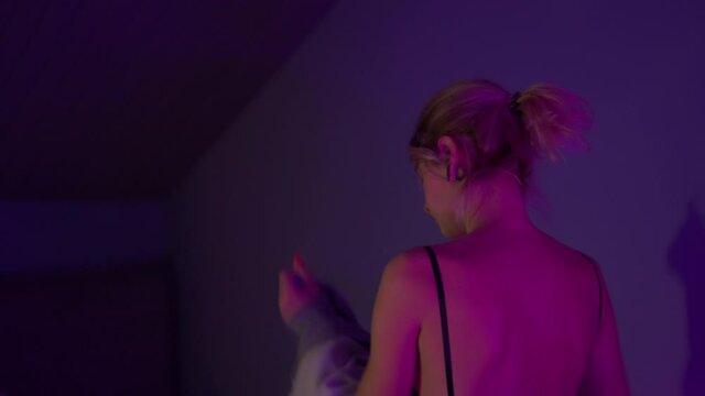 Back View Of Woman Taking Off Clothes At Home