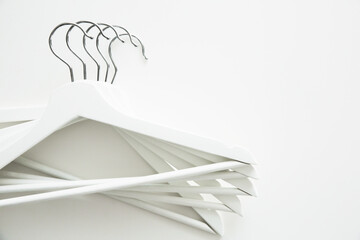 Sale, fashion concept. White wooden clothes hangers and coat hangers on a white background. Copy space.