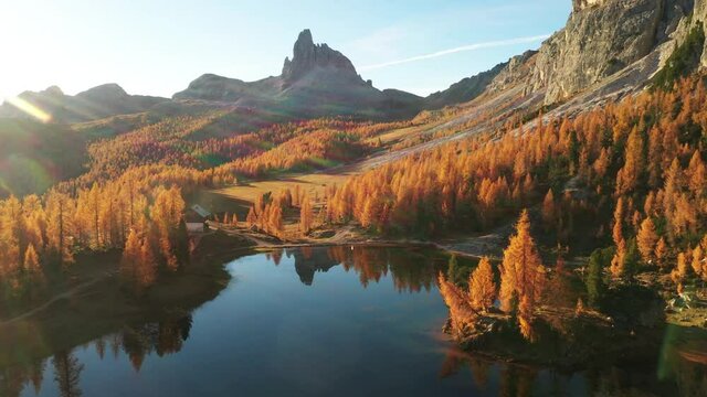 Drone flyght over Federa Lake in sunrise time. Autumn mountains landscape with Lago di Federa and bright orange larches in the Dolomite Apls, Cortina D'Ampezzo, South Tyrol, Dolomites, Italy