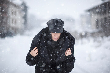A woman walking down a snowy street - 475360313