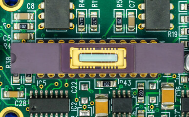 Closeup of a printed circuit board with components such as Resistors and integrated circuits.