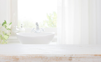 Fototapeta na wymiar Wooden table top on blurred bathroom sink and curtained window