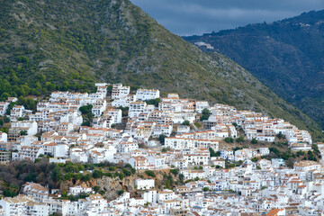 Fototapeta na wymiar Ojén Spain urban view of the city with beautiful green nature around on a cloudy day, small Spanish old town