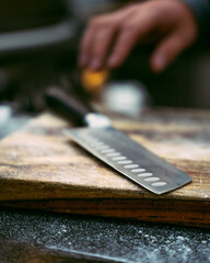 Hand with a knife by cutting board.