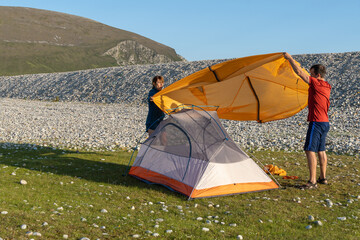 Camping people outdoor lifestyle couple putting up a tent