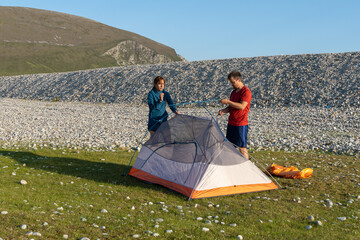 Camping people outdoor lifestyle couple putting up a tent