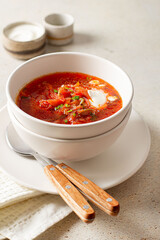 borscht red soup with sour cream in a white plate