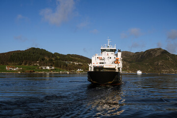 Beautiful landscape of Lusefjord. Mountains and small village. A floating ship.