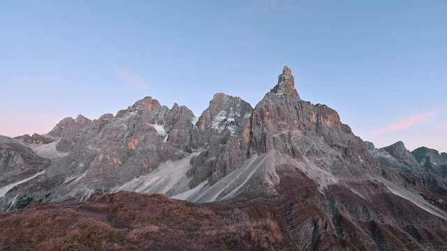 Biutiful morning timelapse video at Pale di San Martino mountain group in sunrise time. Hight mountains with glacier glowing by red sun light. San Martino di Castrozza, Dolomites, Trentino, Italy.