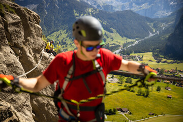 Obraz premium Young people on a via ferrata route in Swiss Alps