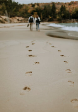 Footsteps in sand of couple walking along sandy beach, Michigan.