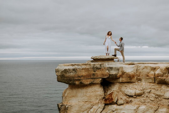Man proposes marriage to woman on cliff, Pictured Rocks, Michigan