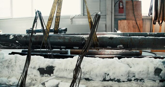 using lifting machines to move metal pipe in a sheet metal factory.