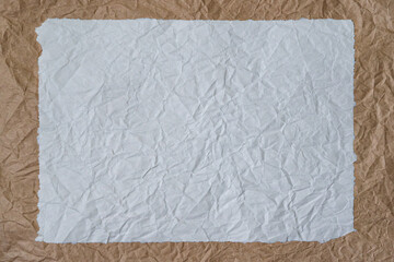 Crumpled light and brown wrapping paper stacked on top of each other in a frame. The edges are unevenly torn off. Background. Texture.