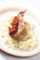 rabbit leg baked with bacon and onion served with rice