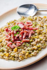 porridge of legumes with fried bacon and chive