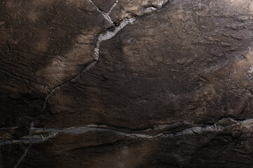 Brown textured clay wall design with cracks and imperfections. Wall design ideas in contemporary interior.