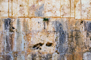 Close-up view of yellow ancient wall. Old wall of large light blocks of marble tiles. Wall with interesting structure. Outdoor and indoor interiors. Grunge texture background