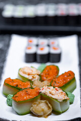 set of sushi rolls with seafood on a black stone background