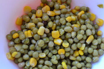 Vegetables, peas and corn on a plate. Healthy diet food. View from above.