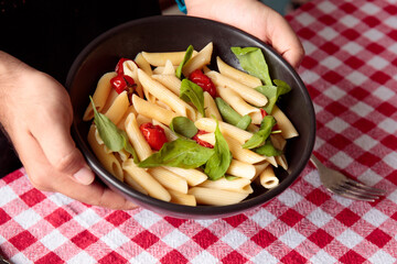 Dish with penne noodles, basil and tomatoes