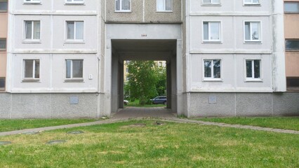 An arched opening in the wall of a residential building for pedestrians to pass from the courtyard...