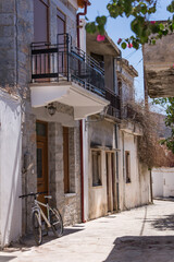 A narrow street with old stone houses and a bike parked at the entrance.