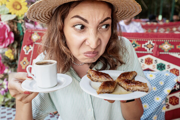 A woman sniffs dessert in a cafe with disgust on her face. The concept of spoiled food and...